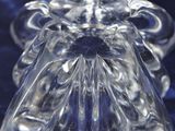 a clear glass angel figurine sitting on a blue surface