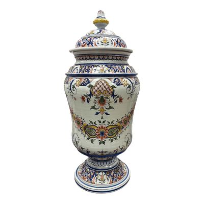un grand vase muni d'un couvercle posé sur une table