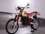 a red and white motorcycle parked in a parking garage