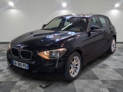 une photo d'une voiture bmw noire garée dans un garage