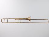 an old brass trombone with a white background