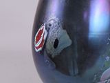 a black vase with a picture on it sitting on a table