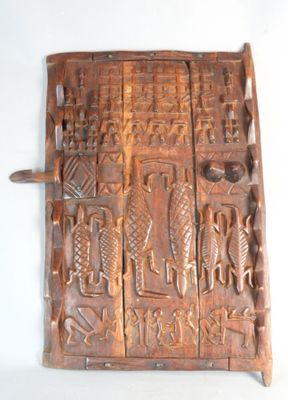 sculptures sur le mur d'une vieille porte en bois munie d'une poignée