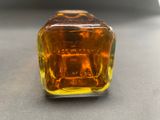 a small glass bottle with a yellow liquid inside of it