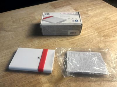 une boîte blanche ornée d'une bande rouge, à côté d'une boîte blanche ornée d'une bande rouge