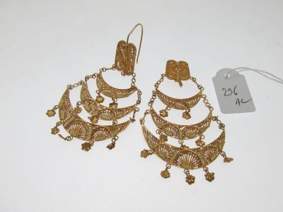 une paire de boucles d'oreilles dorées ornées de chaînes pendantes
