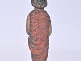 figurine of a woman in a red dress standing on a white surface