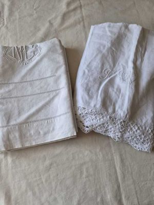 two white napkins on a bed with white sheets