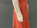 an image of a mannequin wearing a white blouse and orange skirt