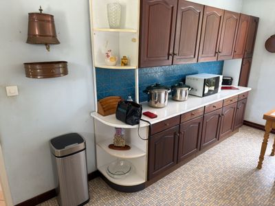 a small kitchen with brown cabinets and a blue backsplash