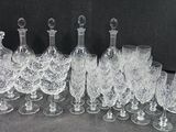 a lot of wine glasses and decanters sitting on a table