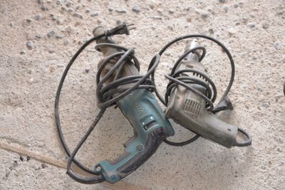 two electric tools laying on the ground next to each other