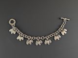 a silver bracelet with elephants on it on a black background