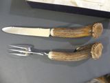 two knives and a fork sitting on a table