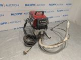 a red and black machine sitting on top of a floor next to a wall