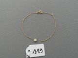 a close up of a gold bracelet with a tag on it