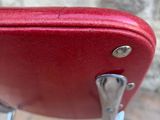 a red piece of luggage that is sitting on a chair