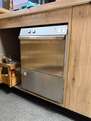 un lave-vaisselle argenté logé à l'intérieur d'un meuble en bois