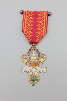une image représentant une médaille rouge et dorée ornée d'une croix