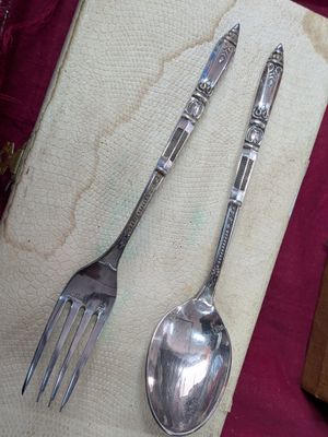 deux cuillères en argent et une fourchette posées sur une serviette