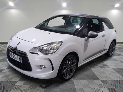 la petite voiture blanche est garée sur un sol en damier