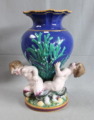 a blue vase with a figurine of a boy and a girl on it
