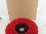 a close up of a red brush on a white surface next to a cardboard box