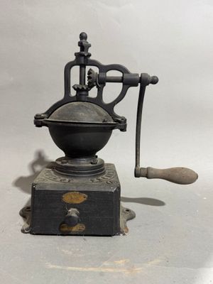 an old coffee grinder sitting on top of a table