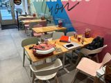 tables and chairs in a restaurant with a sign on the wall