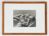 black and white photograph of a woman laying on a couch with a bowl of food