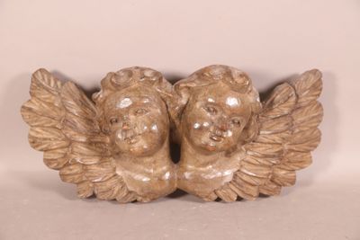 deux statues d'anges assis sur une surface blanche