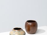 deux petits vases posés côte à côte sur une surface blanche