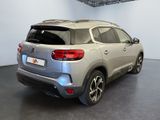 the rear end of a silver suv parked in a showroom
