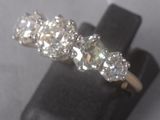 an image of a three stone diamond ring sitting on top of a black ring holder