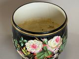 a black and white cup with a floral design on it
