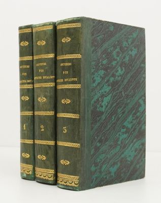 two green books sitting on top of each other on a white surface