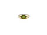 a close up of a ring with a green stone in it