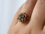 a woman ' s hand holding a ring with a diamond on it