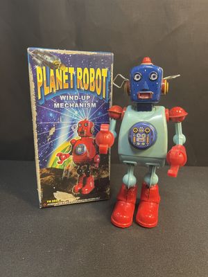 a close up of a toy robot next to a book on a table