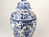 un vase bleu et blanc avec un couvercle posé sur une table
