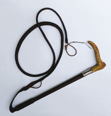 une canne noire avec un manche marron et une corde attachée dessus