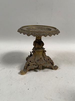 une petite table sur laquelle est posé un oiseau, posée sur une surface blanche
