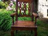 a wooden chair that is sitting in the grass