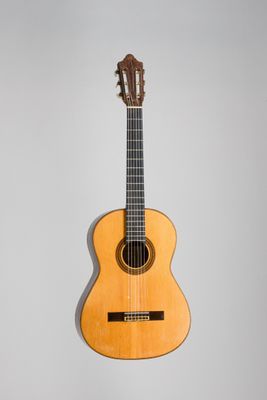 une vieille guitare acoustique accrochée au mur