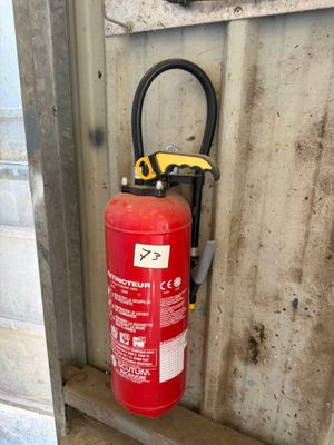 un extincteur fixé au mur d'un immeuble