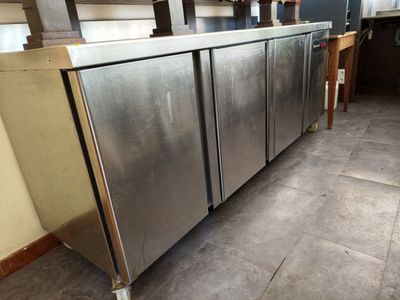 a stainless steel refrigerator in the middle of a kitchen
