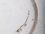 a white plate with a brown rim that has a brown line on it