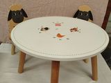 une petite table avec deux chaises et un mouton dessus