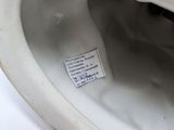 a white porcelain toilet with a label on the lid