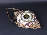 a clock that is sitting on a chain on a table